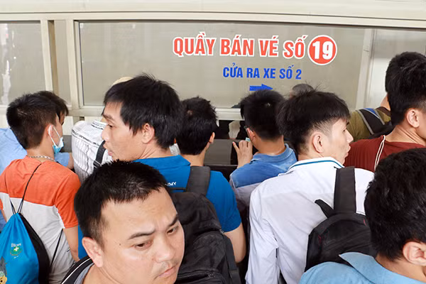 Phía trong bến xe là cảnh chen lấn, xô đẩy tại quầy bán vé, ai cũng sốt ruột muốn mua vé chuyến sớm để về quê