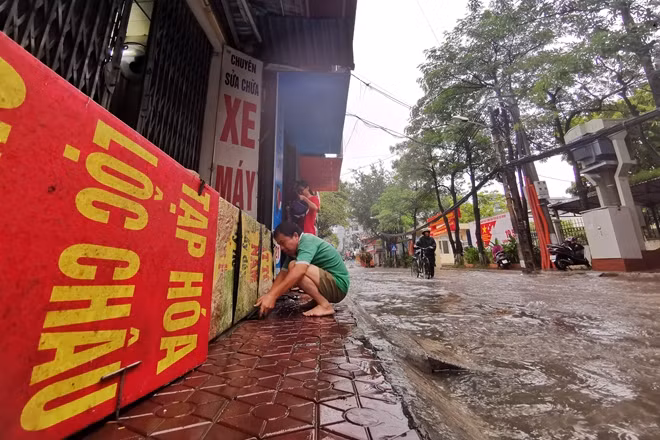 Trước tình hình nước dâng cao ngày một nhanh, các hộ dân trên đường Trần Bình buộc phải "Xây chiến lũy" bằng các tấm biển quảng cáo, lốp xe để ngăn nước tràn vào nhà.