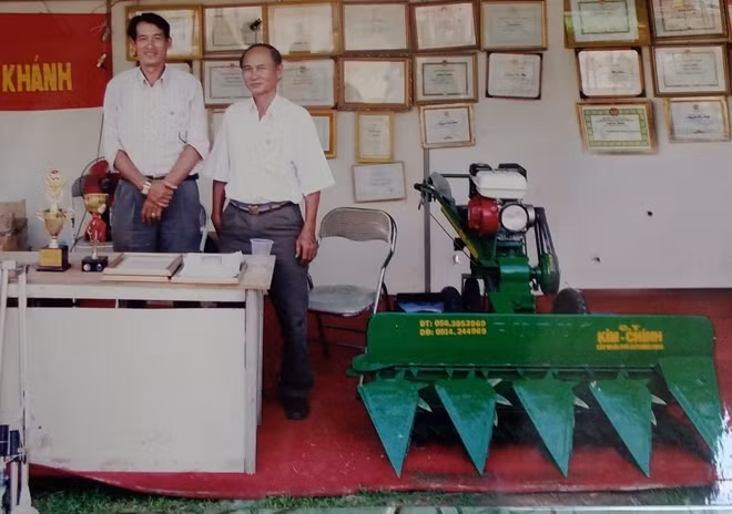 Ông Chính (trái) bên máy gặt lúa rải hàng cải tiến trong một lần tham dự hội chợ.