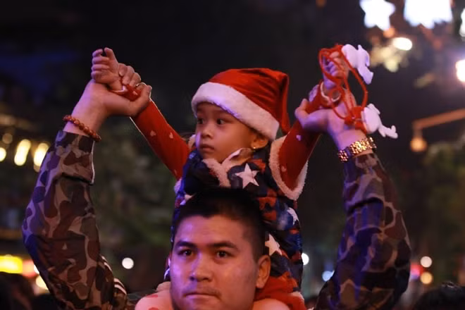 Bé trai lạ lẫm với không khí đông đúc, vui nhộn đêm Noel ở Hà Nội.