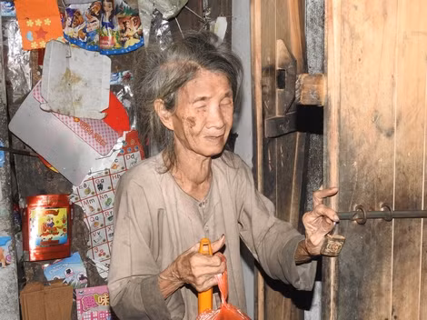 Bà Nguyễn Thị Hồ lần từng bước chân để mở cửa nhà. Bà Nguyễn Thị Hồ lần từng bước chân để mở cửa nhà.