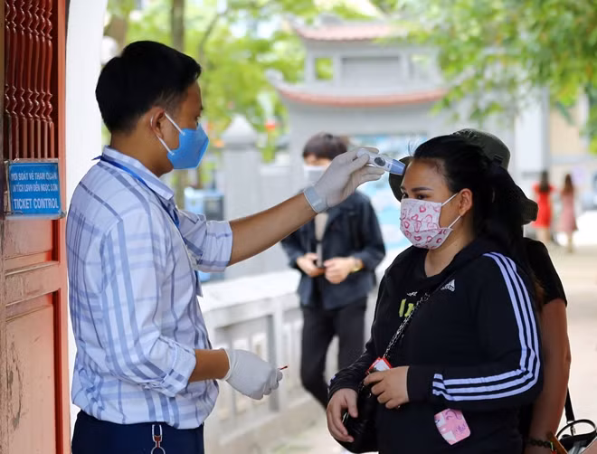 Tại Di tích Đền Ngọc Sơn, nhân viên với máy đo nhiệt độ được bố trí ngay từ cổng vào để kiểm tra thân nhiệt của du khách trước khi vào thăm quan.
