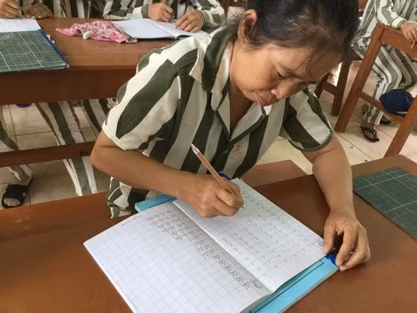 Lương Thị Dạng nắn nót tập viết. Lương Thị Dạng nắn nót tập viết.