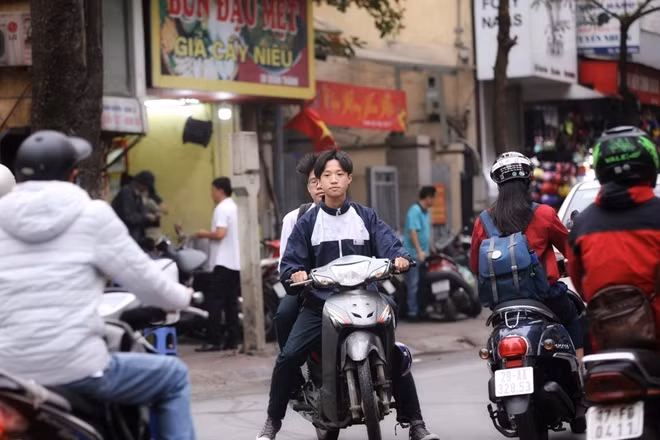 Hai bạn trẻ học sinh điều khiển xe máy khi chưa đủ tuổi và không hề đội mũ bảo hiểm.