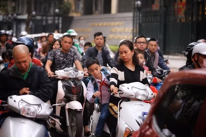 Từ người lớn đến trẻ nhỏ đều vô tư quên mũ bảo hiểm.
