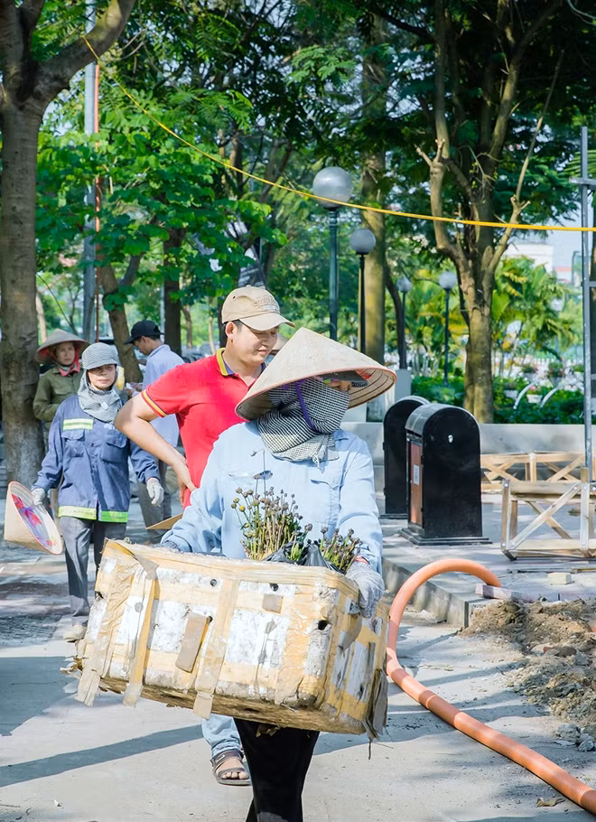Công nhân hối hả dọn dẹp rác rưởi sau thi công trên phố đi bộ.