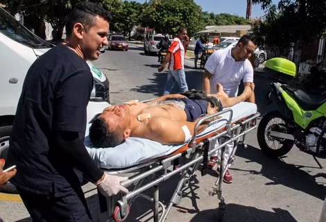 Chuyển một cảnh sát bị thương tại hiện trường vụ tấn công ở Barranquilla, Colombia ngày 27-1.