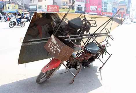 Một chiếc xe máy cũ kĩ với hàng hóa trên xe.
