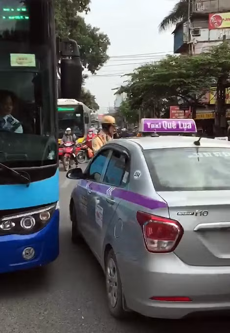 Chiếc taxi cố tình đẩy lùi chiến sỹ CSGT trên phố.