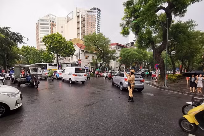 Lực lượng CSGT chật vật để điều tiết giao thông giữa cơn mưa.