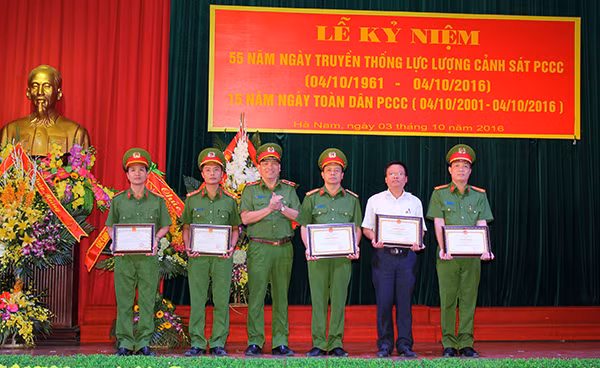 Thiếu tướng Đỗ Minh Dũng, Phó Cục trưởng Cục Cảnh sát PCCC và cứu nạn, cứu hộ BCA tặng Giấy khen cho các tập thể, cá nhân có thành tích xuất sắc tại lễ kỷ niệm 55 năm ngày truyền thống lực lượng Cảnh sát PCCC và cứu nạn, cứu hộ, 15 năm ngày toàn dân PCCC.