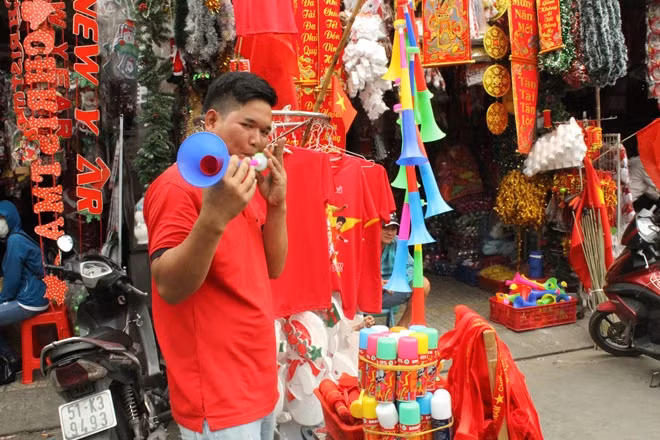 Một CĐV đang tranh thủ mua cho mình chiếc kèn để chuẩn bị cho tối nay cổ vũ bóng đá.