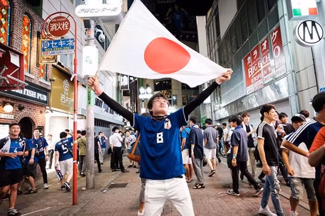 Một CĐV với quốc kỳ Nhật Bản ăn mừng trên đường phố thủ đô Tokyo. Ảnh: Fox Soccer.