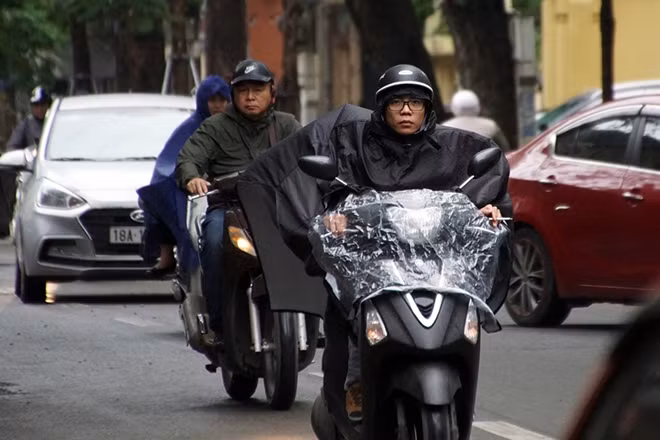 Ngoài việc tự trang bị cho mình thêm áo ấm, khăn len để giữ ấm cơ thể, hầu hết người dân khi ra đường đều phải mặc thêm áo mưa để chống lại cái lanh giá của cơn mưa sáng sớm.