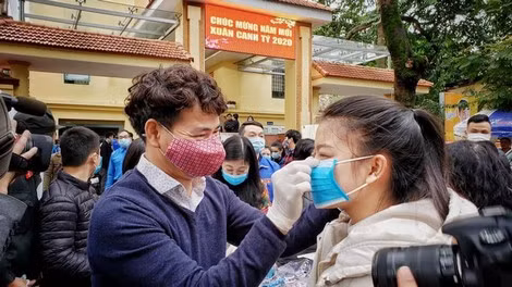 NSƯT Xuân Bắc đeo khẩu trang cho người dân.