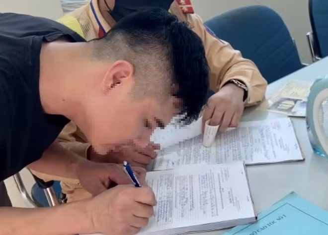 Lái xe ký biên bản vi phạm.