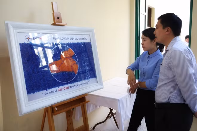 Cán bộ, công nhân viên ngắm nhìn bức tranh.