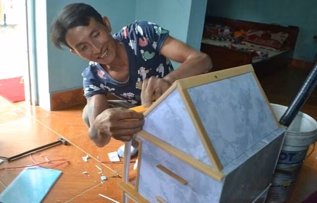 Anh Tuấn hào hứng làm ngôi nhà đồ chơi cho con trai.