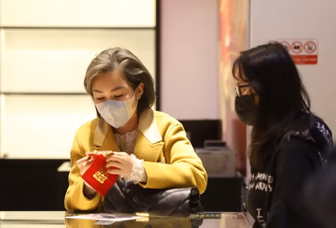 Một khách hàng kiểm tra lại vàng vừa mua tại cửa hàng.