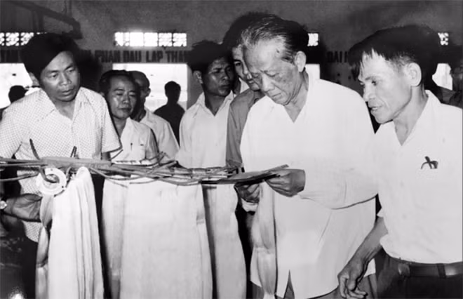 Tổng Bí thư Lê Duẩn (thứ 2, phải sang) đang xem các sản phẩm từ dâu tằm trong chuyến thăm huyện Điện Bàn, tỉnh Quảng Nam năm 1983 (Nhà báo Dương Đức Quảng ngoài cùng, trái).