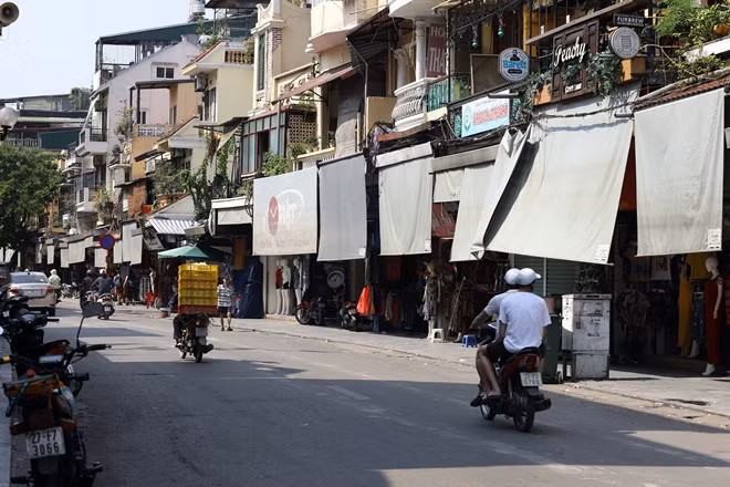 Cả ngày đón nắng, nhiều tiểu thương, hộ kinh doanh trên phố Hàng Đào phải dùng bạt che chắn để tránh đợt nắng nóng gay gắt.
