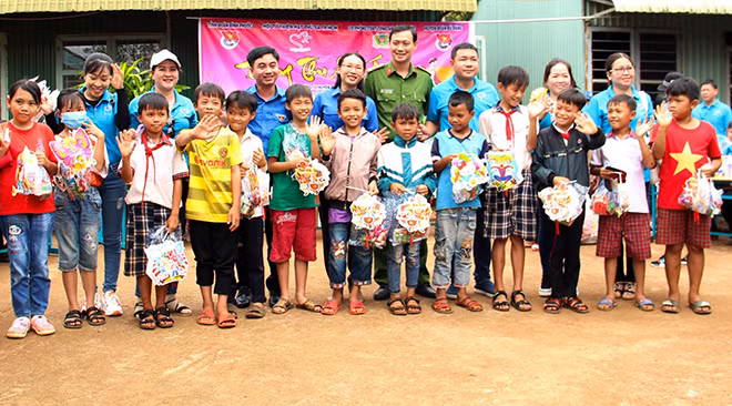 Lãnh đạo Tỉnh Đoàn Bình Phước cùng anh Lê Văn Hữu - đại diện Hội từ thiện Hạt Phù Sa và Chi đoàn Phòng Cảnh sát kinh tế (Công an tỉnh) trao quà Trung thu cho các em thiếu nhi xã Đường 10, huyện Bù Đăng, tỉnh Bình Phước