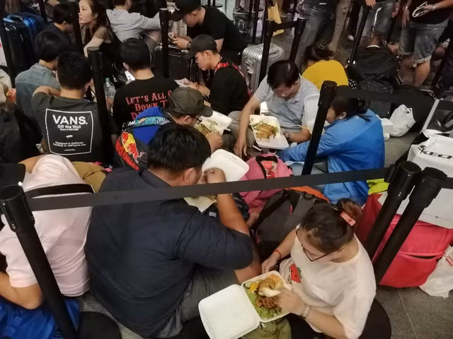 Sau khi cơn mưa dứt, tất cả trở lại ví trí chờ đợi ban đầu, nhiều người tranh thủ ăn tối lấy sức chờ đến sáng hôm sau. Ảnh: Gia Hưng Sau khi cơn mưa dứt, tất cả trở lại ví trí chờ đợi ban đầu, nhiều người tranh thủ ăn tối lấy sức chờ đến sáng hôm sau. Ảnh: Gia Hưng
