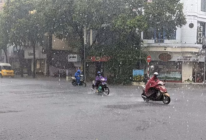 Ngay sau đó, trận mưa lớn bắt đầu trút xuống Hà Nội. Mưa trắng xóa trời khiến người điều khiển xe máy bị khuất tầm nhìn, di chuyển khó khăn. Ảnh: VTC.