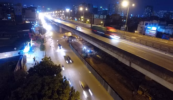 Trong tiết trời lạnh giá của mùa đông Hà Nội, từ đêm ngày 2-1, công nhân thuộc các công ty công trình giao thông Hà Nội bắt đầu rào chắn và xén dải phân cách dưới gầm cầu cạn để mở rộng đường tại phố Nguyễn Xiển hướng đi cầu vượt Mai Dịch.