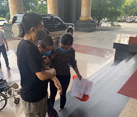 Anh Tú khó nhọc bước lên bậc thềm để vào phòng xét xử.