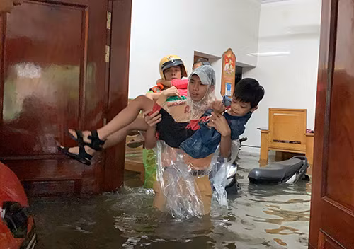 CSGT bế các em nhỏ ra khỏi nhà bị ngập sâu trong ngõ thuộc Khối 13 phường Bến thủy, TP Vinh