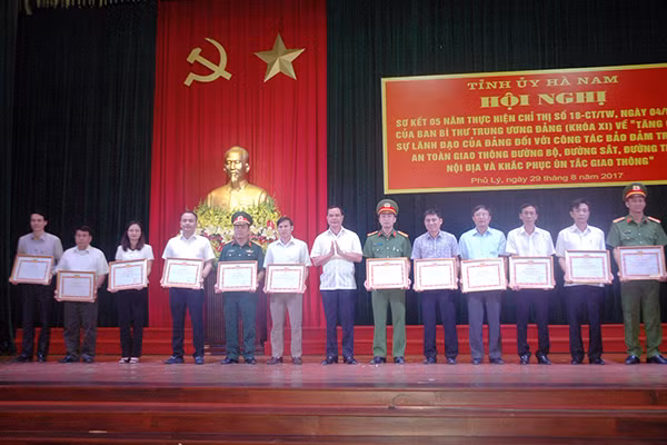 Đồng chí Nguyễn Đình Khang, Bí thư tỉnh ủy Hà Nam trao Bằng khen cho các tập thể xuất sắc trong thực hiện Chỉ thị 18 Ban Bí thư