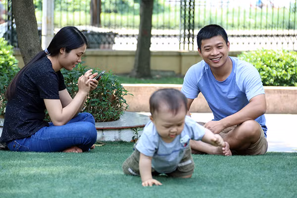 Ánh mắt hạnh phúc của người bố khi ngắm nhìn con bò trên thảm cỏ công viên. Ánh mắt hạnh phúc của người bố khi ngắm nhìn con bò trên thảm cỏ công viên.