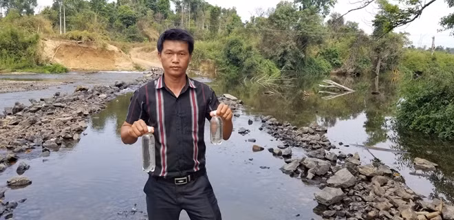 Ông Thái Anh Tuấn, Phó trưởng Phòng Tài nguyên và Môi trường huyện Ia Grai lấy mẫu nước để gửi đi phân tích.