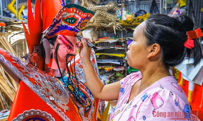 Đôi tay khéo léo của một người thợ đang tô điểm cho bức tượng vàng mã.