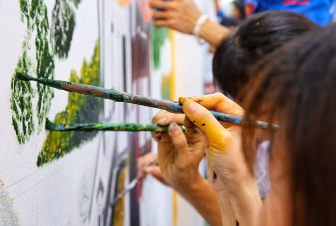 Những đôi bàn tay chăm chỉ cùng nhiệt huyết của tuổi trẻ đang thay "áo mới" cho bức tường nhếch nhác ngày nào.