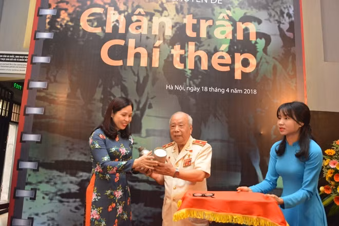 Đồng chí Nguyễn Bích Thủy, Trưởng ban Quản lý Di tích Nhà tù Hỏa Lò tiếp nhận hiện vật từ Thiếu tướng, Anh hùng LLVTND Nguyễn Đức Minh, nguyên cựu tù chính trị Nhà tù Hỏa Lò.