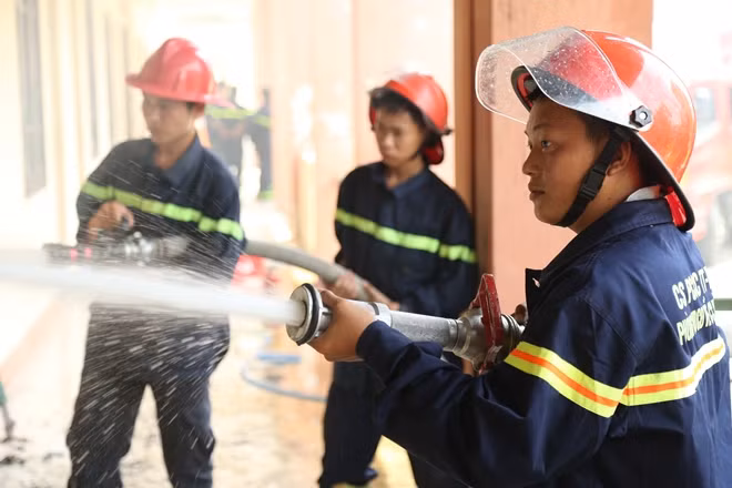 Thượng úy Lê Văn Kỳ (góc phải) đang cùng đồng đội chữa cháy tại ký túc xá Trường Bia, Đại học Huế.