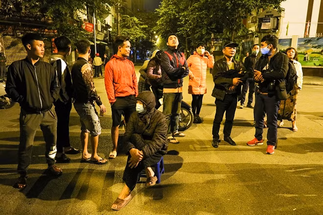 Người dân chờ đợi bên ngoài, theo dõi tình hình.