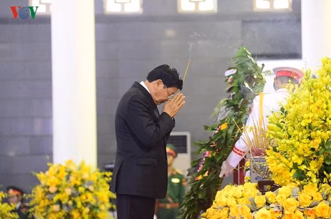 Thủ tướng Lào Thongloun Sisoulith kính cẩn thắp hương tưởng niệm nguyên Tổng Bí thư Đỗ Mười. (Ảnh: Hà Phương)