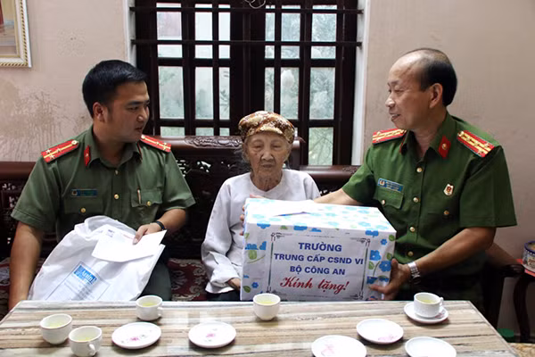 Đại diện Đoàn Thanh niên Báo Công an nhân dân và Đoàn trường Trung cấp Cảnh sát nhân dân 6 tặng quà bà mẹ Việt Nam anh hùng Đỗ Thị Bón.
