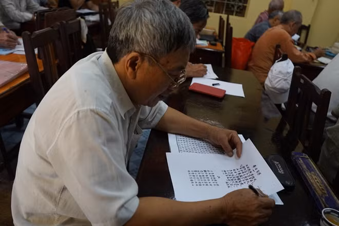 Một lão sinh đang nghiên cứu văn bản được phát.