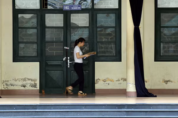 7h25, đề thi bắt đầu được giám thị chuyển tới phòng thi.