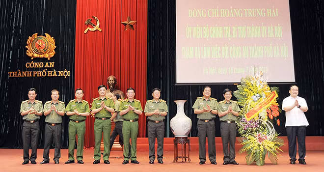 Đồng chí Hoàng Trung Hải tặng hoa chúc mừng lực lượng ANND và CSND Công an Hà Nội nhân ngày truyền thống