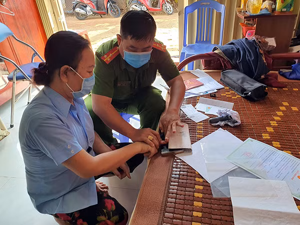 Cán bộ Tổ cấp, phát CMND giúp người dân lăn tay.