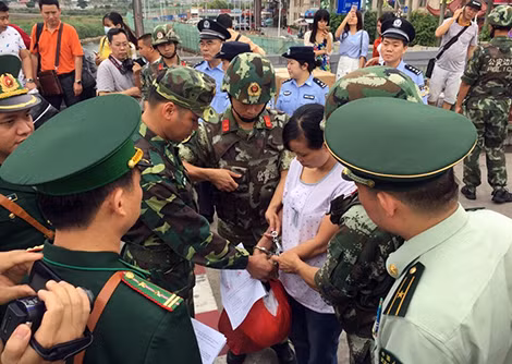 Lực lượng chức năng Việt Nam - Trung Quốc bàn giao đối tượng truy nã Dương Thị Hà (áo trắng) tại cửa khẩu quốc tế Móng Cái. Lực lượng chức năng Việt Nam - Trung Quốc bàn giao đối tượng truy nã Dương Thị Hà (áo trắng) tại cửa khẩu quốc tế Móng Cái.