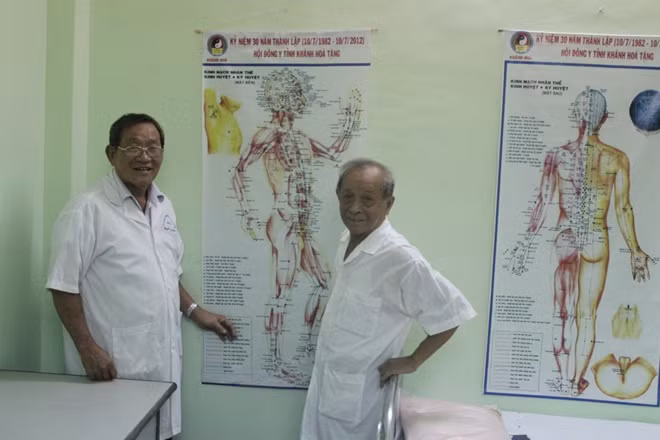 Bác sĩ Đồng và lương y Nguyễn Trung Kiên bên phác đồ điều trị đông y để điều trị miễn phí cho người nghèo, cựu chiến binh khó khăn.