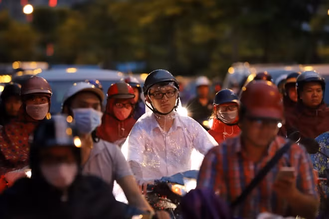 Người dân mệt mỏi chờ đợi giữa dòng xe ken đặc sau cơn mưa.