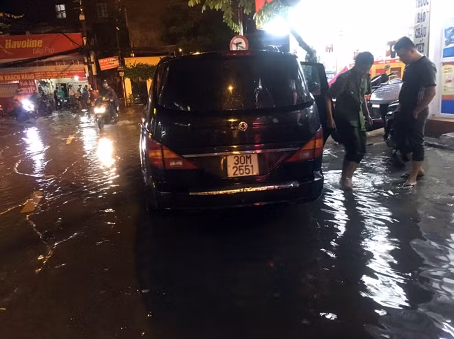 Một xe ô tô đi qua vùng ngập bị chết máy.