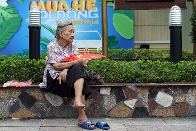 Cụ bà thảnh thơi ngắm nhìn phố phường yên bình.